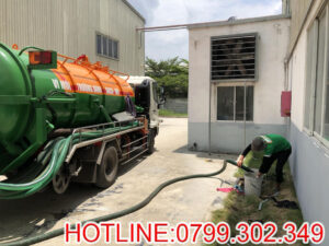 Ảnh nhân viên đang thao tác hút hầm cầu bằng xe chuyên dụng.